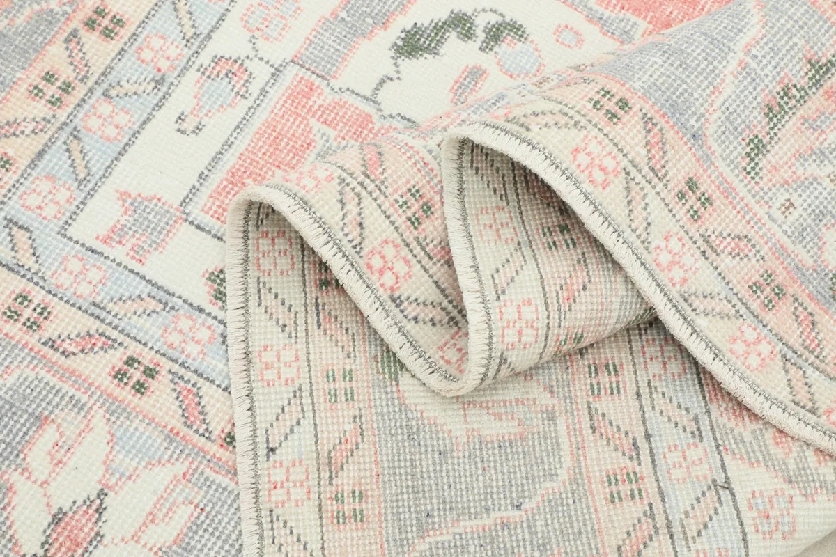 Rug folded to display the thickness and texture of the vintage wool pile and cotton foundation.