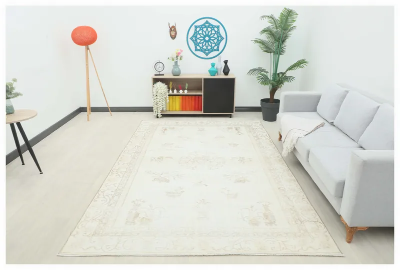 Full overhead view of a cream and beige floral vintage Anatolian area rug on a white background.