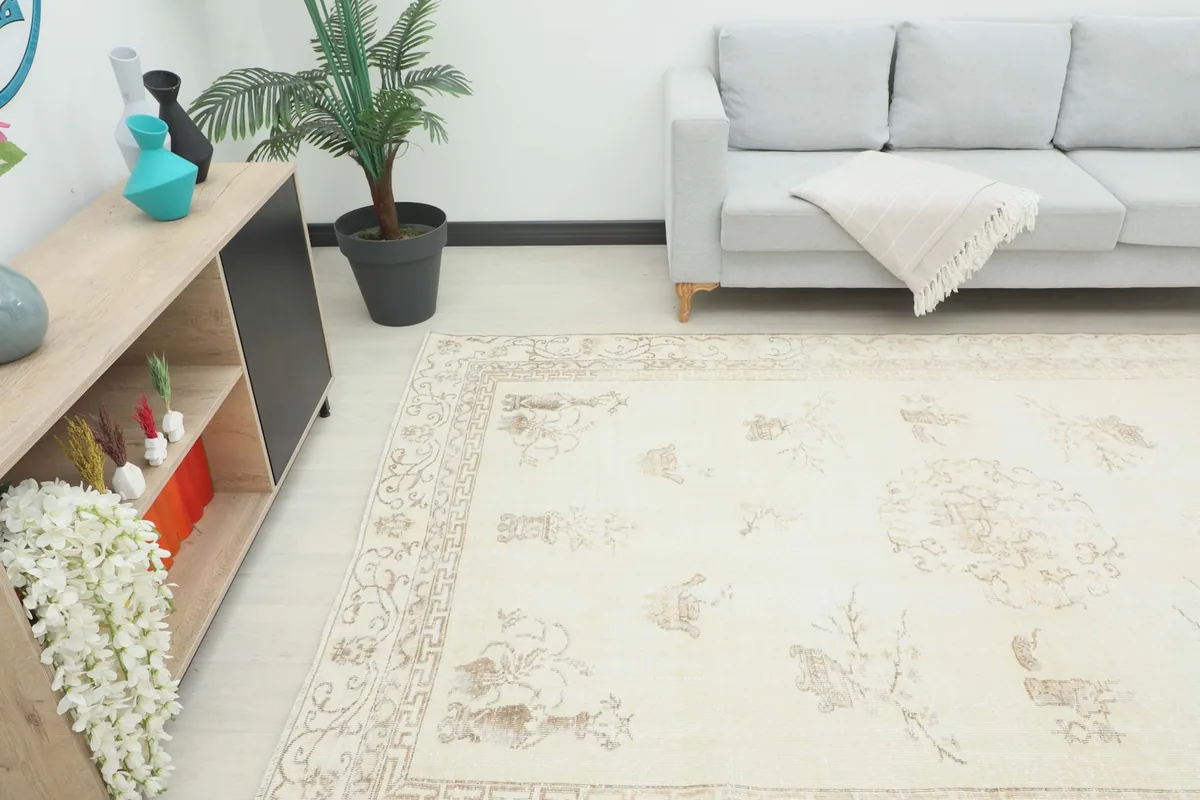 Angle view of the cream and beige rug laid out in a room, showing its scale next to furniture.