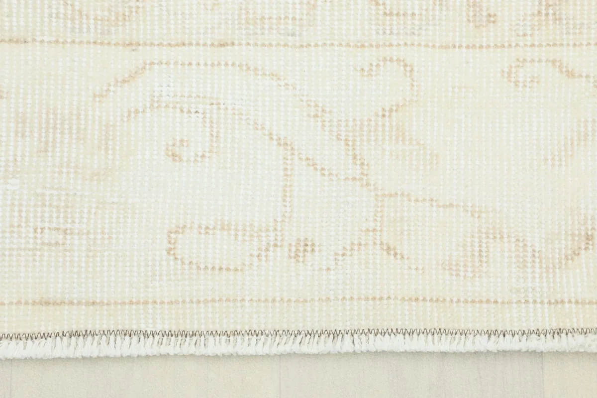 Close-up detail of the cream field and beige floral motifs, showing the low pile texture.