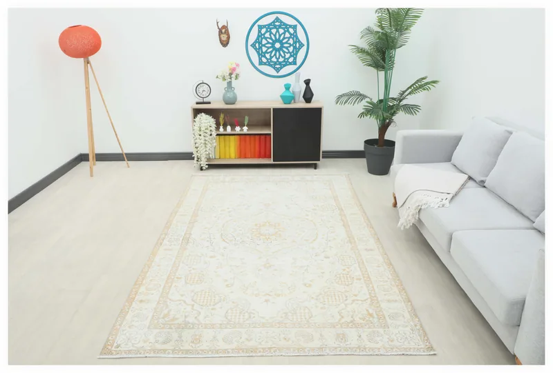 Full overhead view of the 5'5" x 8'5" ivory and gold floral medallion rug on a white background.