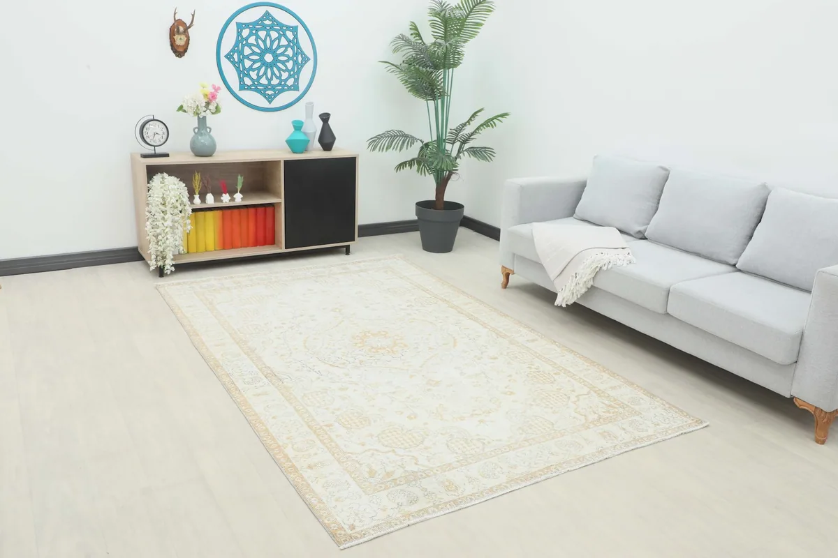 Vintage Anatolian rug displayed in a living room setting with a light gray sofa and modern decor.