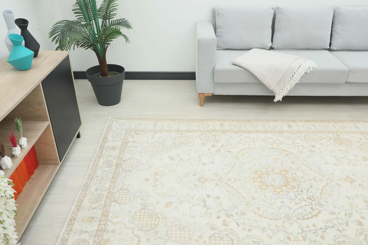 Angled view of the rug in a room, showing its placement relative to a sofa and console table.