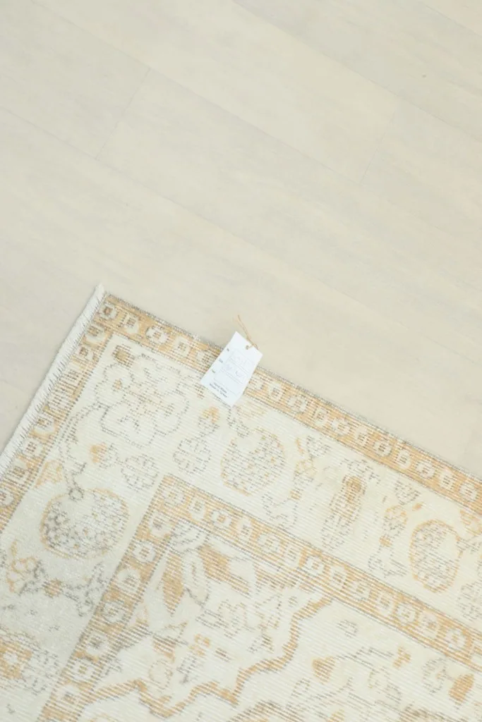 Overhead view of the rug's back, showing the tightly woven cotton foundation and a small tag.