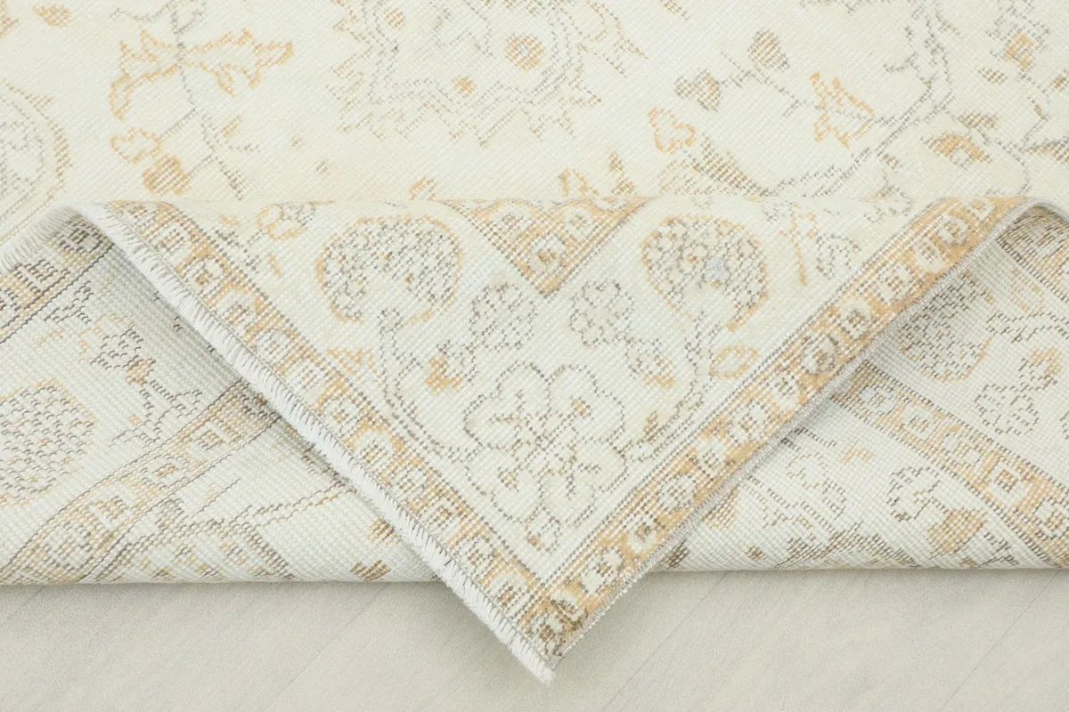 Corner of the rug folded back, revealing the reverse side of the hand-knotted construction.