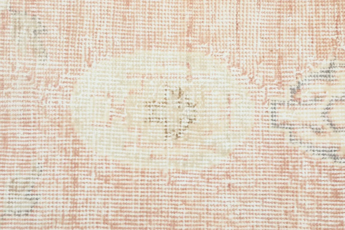 Extreme close-up of the low wool pile, showcasing the hand-knotted texture and distressed areas.
