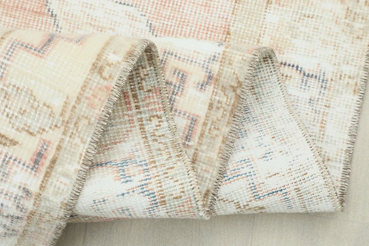 Close-up of the rug's fold, highlighting the tightly woven wool pile and cotton foundation structure.
