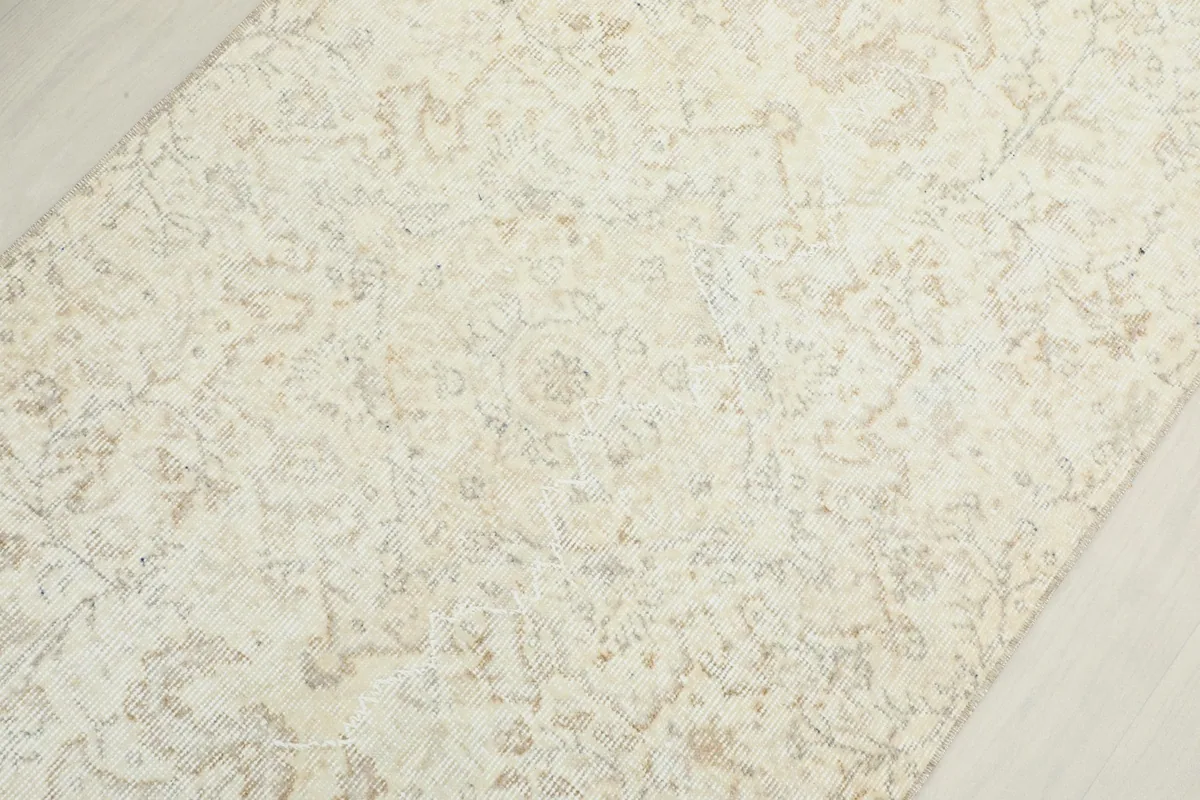 Overhead close-up of the rug's center, revealing the intricate, faded floral and medallion motifs.