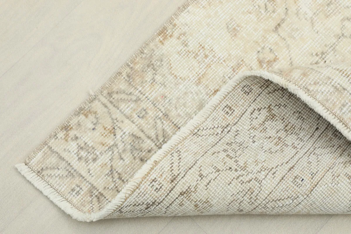 View of the rug's underside, revealing the cotton foundation and hand-knotted stitches.