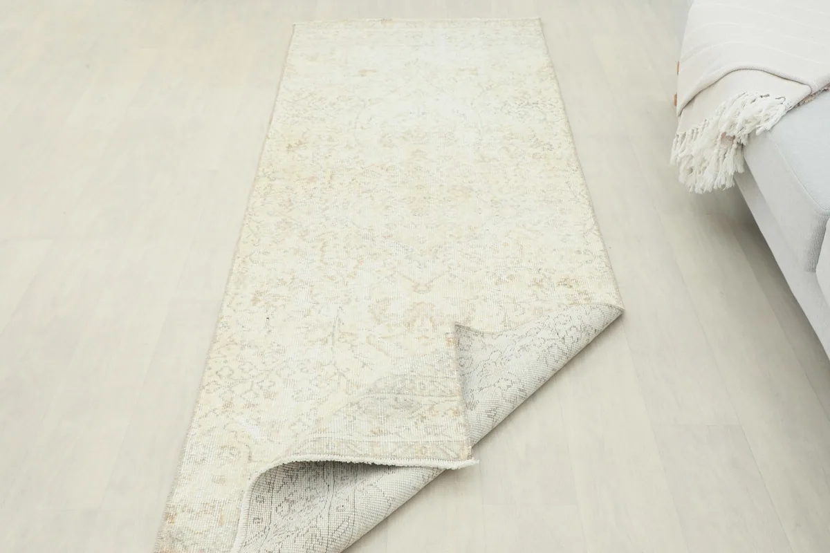 Rug partially folded, showing the flexibility and thickness of the vintage hand-knotted wool.