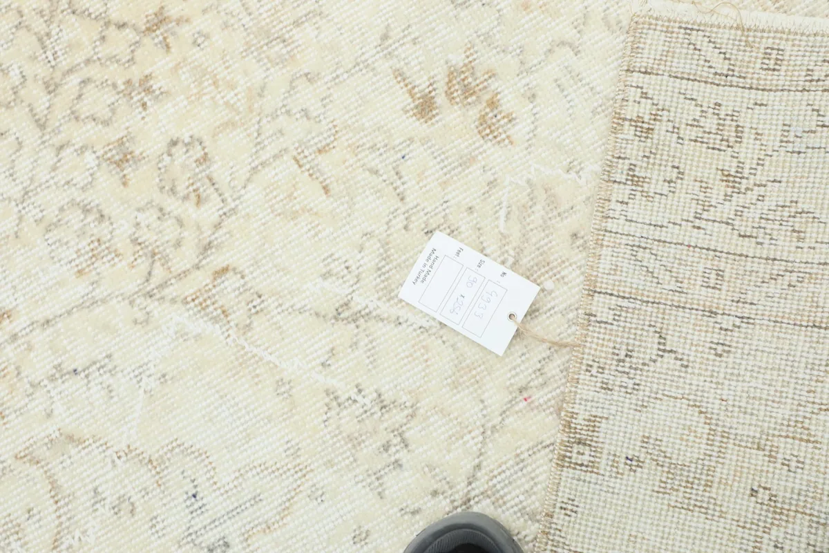 Overhead view showing the rug's label and a comparison of the front pile with the back foundation.