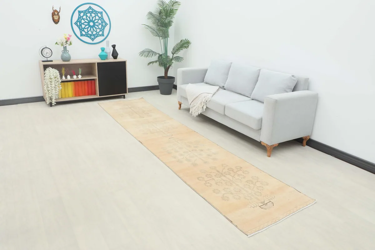 Vintage runner rug laid out in a living room scene with a sofa and decor