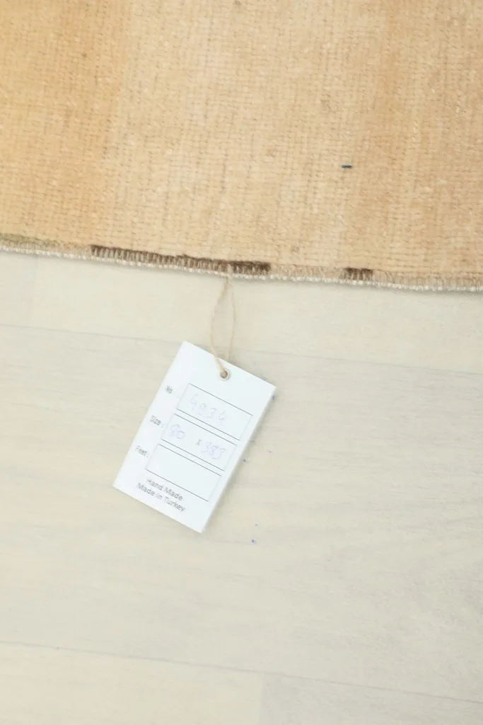 Close-up of a RugsKilim product tag attached to the vintage Anatolian runner rug