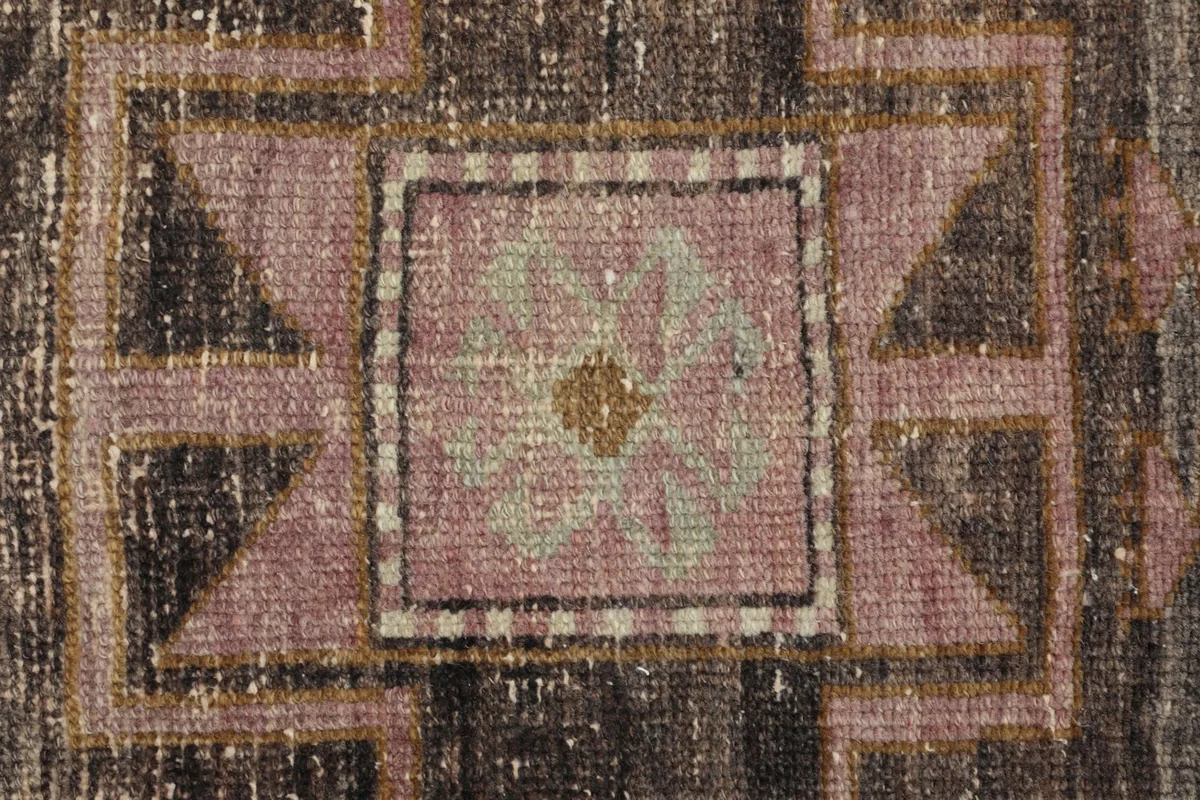 Macro detail of the hand-knotted wool pile, showing texture and color variations within a medallion