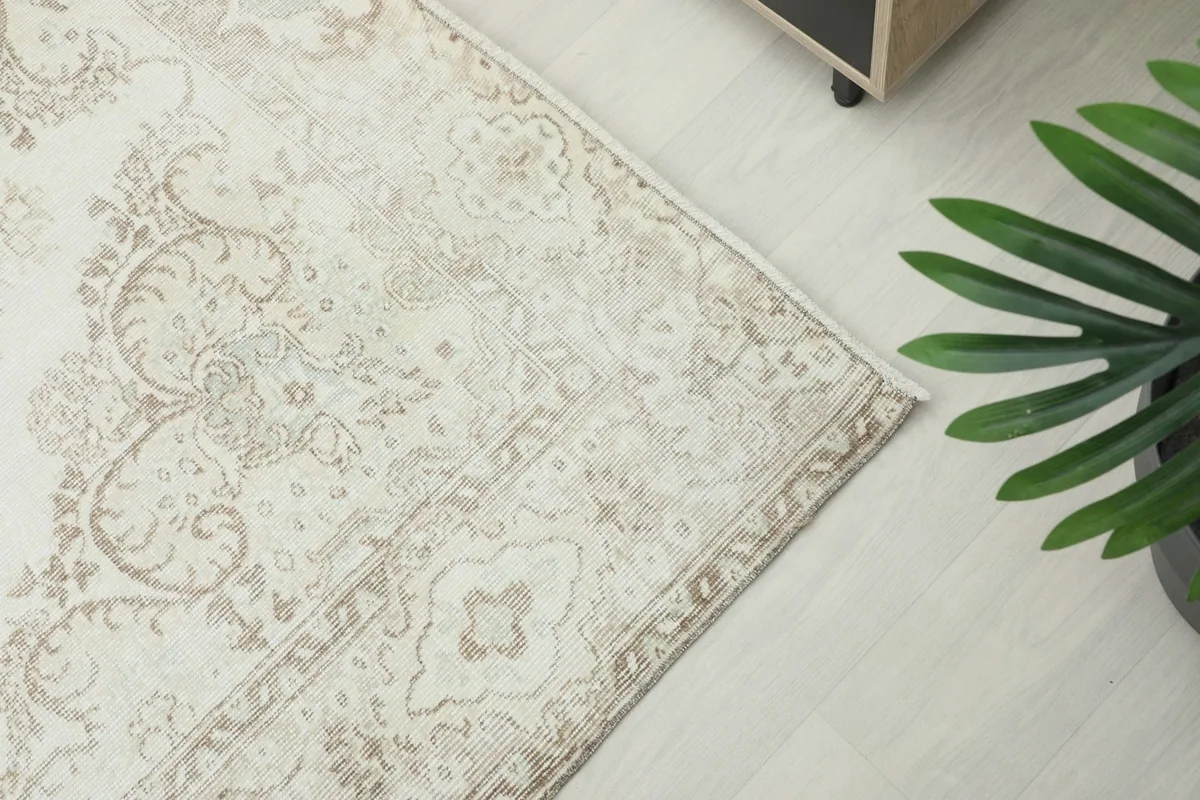 Close-up of the rug's corner, highlighting the detailed beige border and subtle patterns.