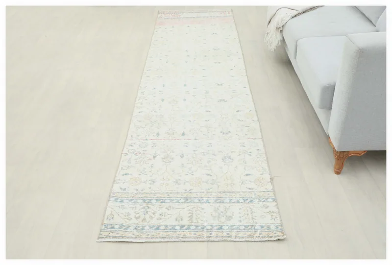 Full overhead view of the 2'7" x 10'5" cream Anatolian runner rug on a light floor.