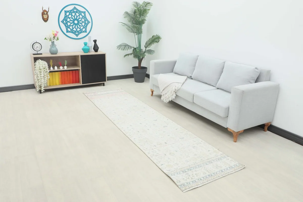 Runner rug in a room setting next to a light gray sofa and a small side table.