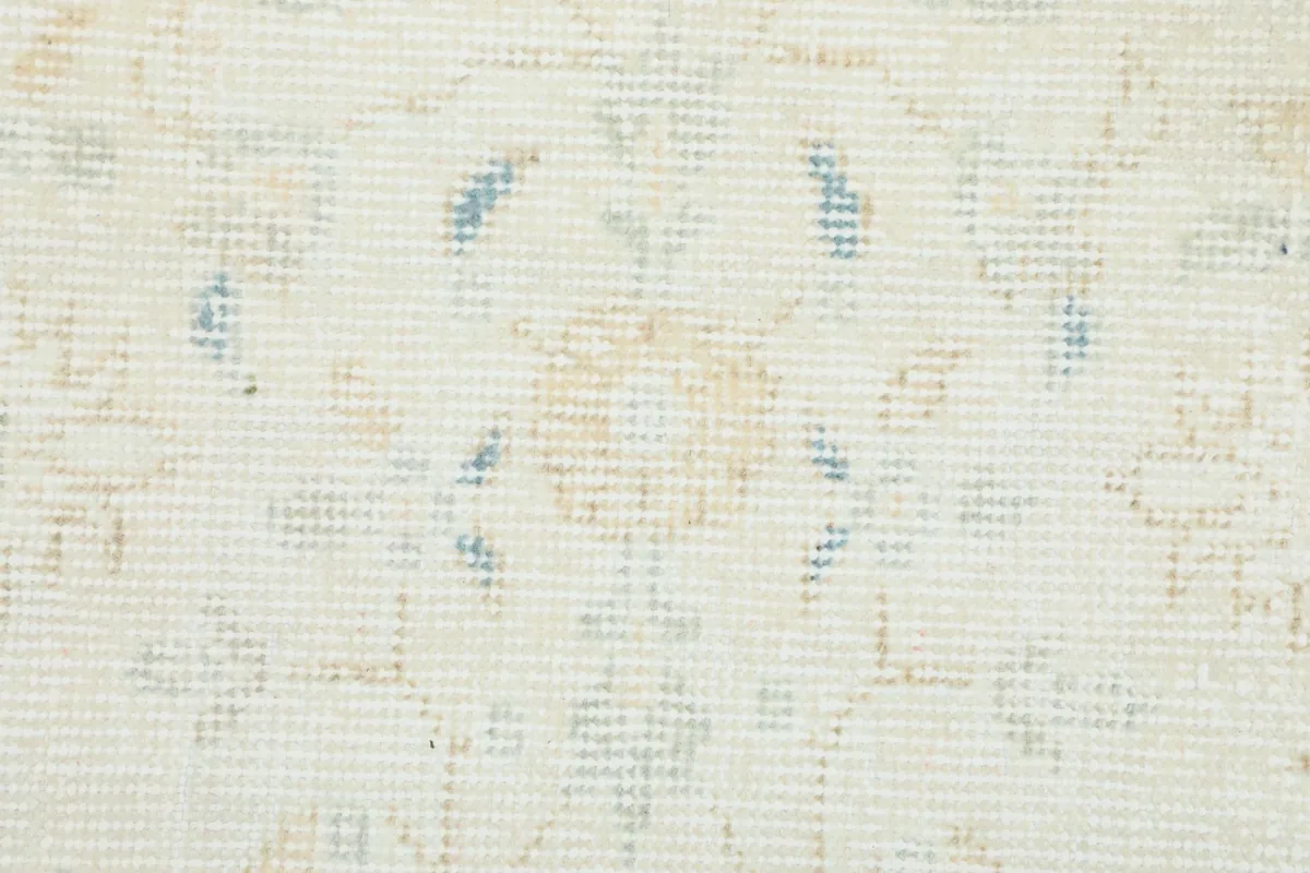 Extreme close-up showing the low wool pile and hand-knotted texture of the rug.