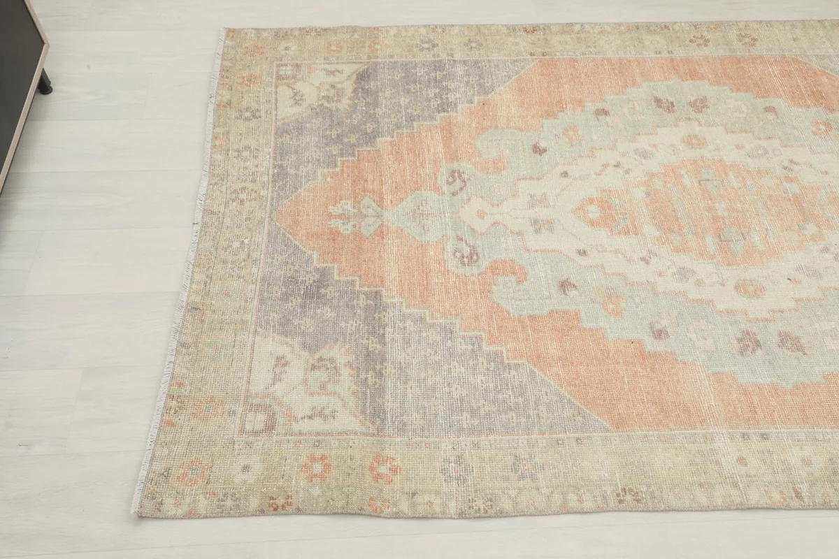 Another angle view of the vintage rug, capturing the interplay of rust, gray, and beige colors.