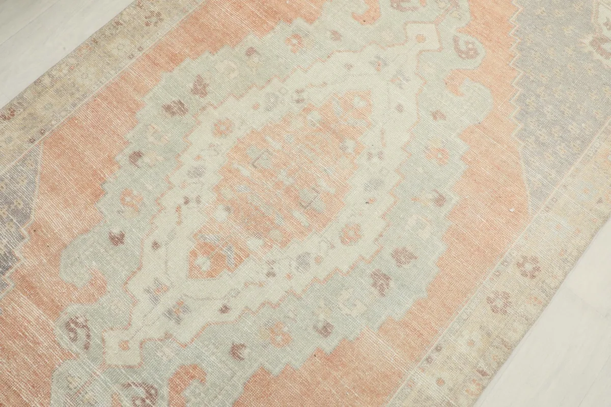 Detailed view of the central rust and beige medallion and surrounding gray geometric patterns.