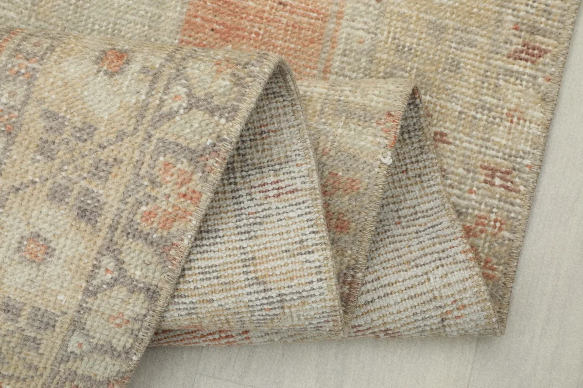 Close-up of the rug's folded edge, highlighting the hand-knotted wool and cotton foundation.