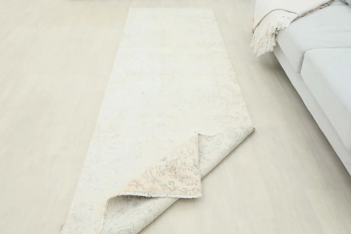 Runner rug partially folded, illustrating its flexibility and the texture of the reverse side.
