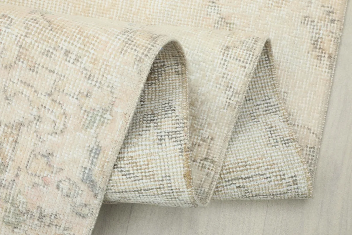 Close-up of the rug folded, emphasizing the soft texture of the wool pile and the foundation.