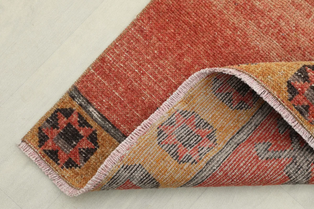 Angled view of the runner's end, showing the border design and the wool pile texture.