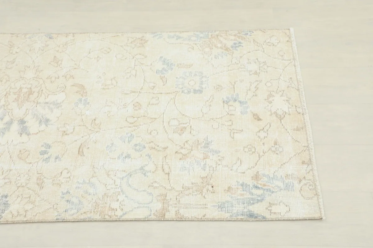 Close-up of the beige field with subtle blue and tan floral patterns.