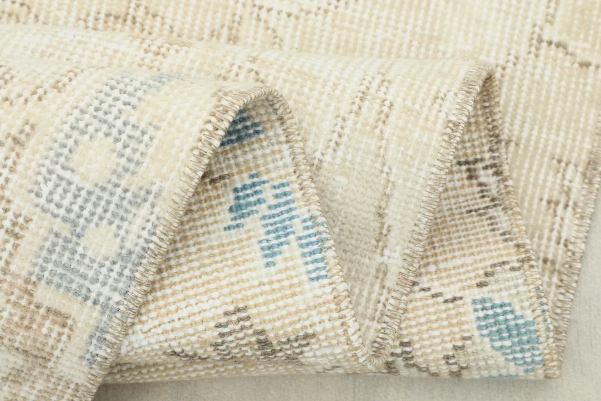 Detailed view of the rug's construction and colors from a folded angle.
