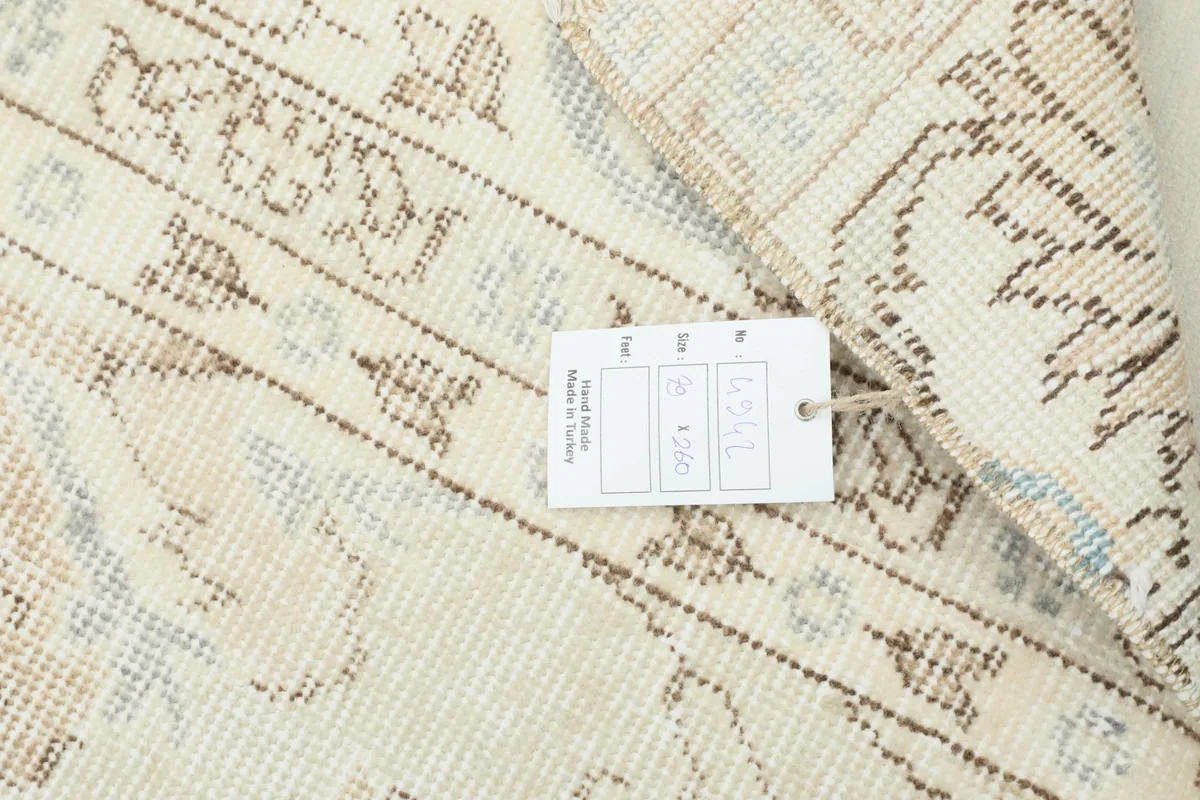 Close-up showing the product tag attached to the vintage Anatolian runner.