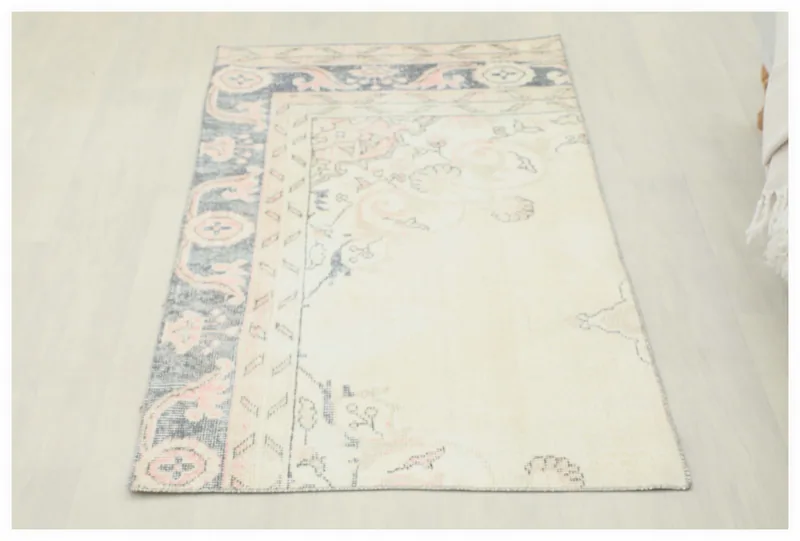 Full top view of the 2'7" x 4'9" ivory, navy, and rose vintage Anatolian rug