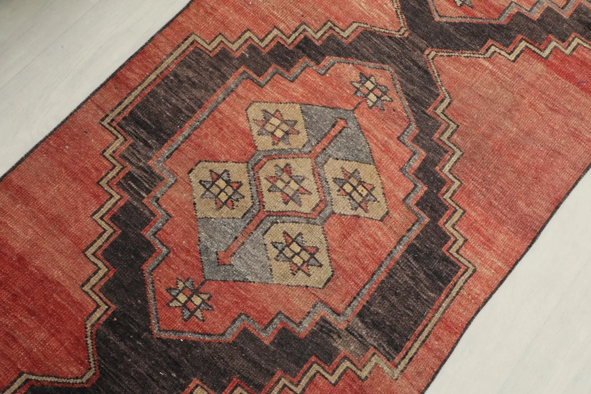 Detailed view of the central geometric motif, showing the intricate hand-knotted wool pile.