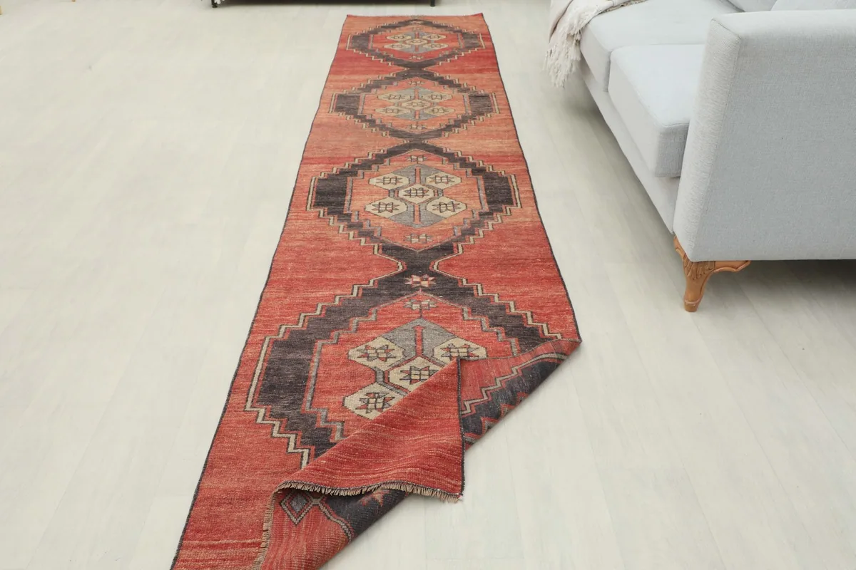 Runner rug partially folded, showing its flexibility and the repeating geometric design.