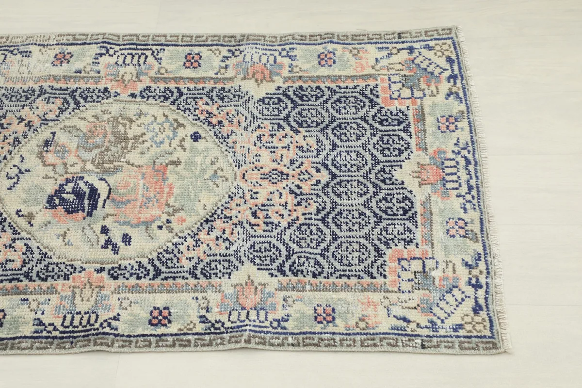 Close-up of the rug's border and part of the navy field with geometric patterns.