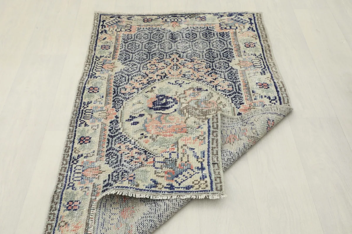 Rug folded back to show the reverse side and the hand-knotted craftsmanship.