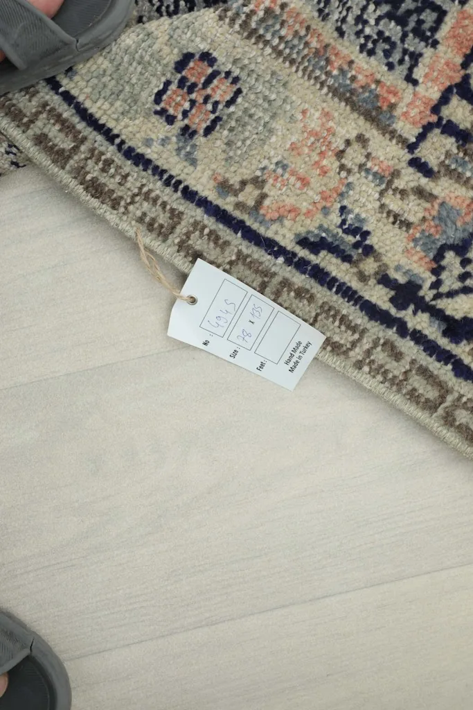 Corner of the rug with a product tag showing size details.