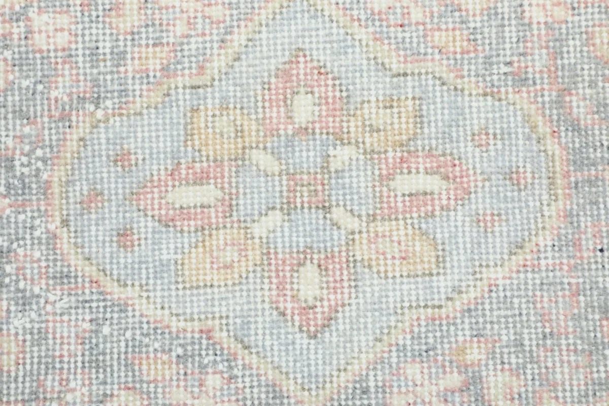 Detailed close-up of a central geometric motif, highlighting the subtle color variations and low pile.