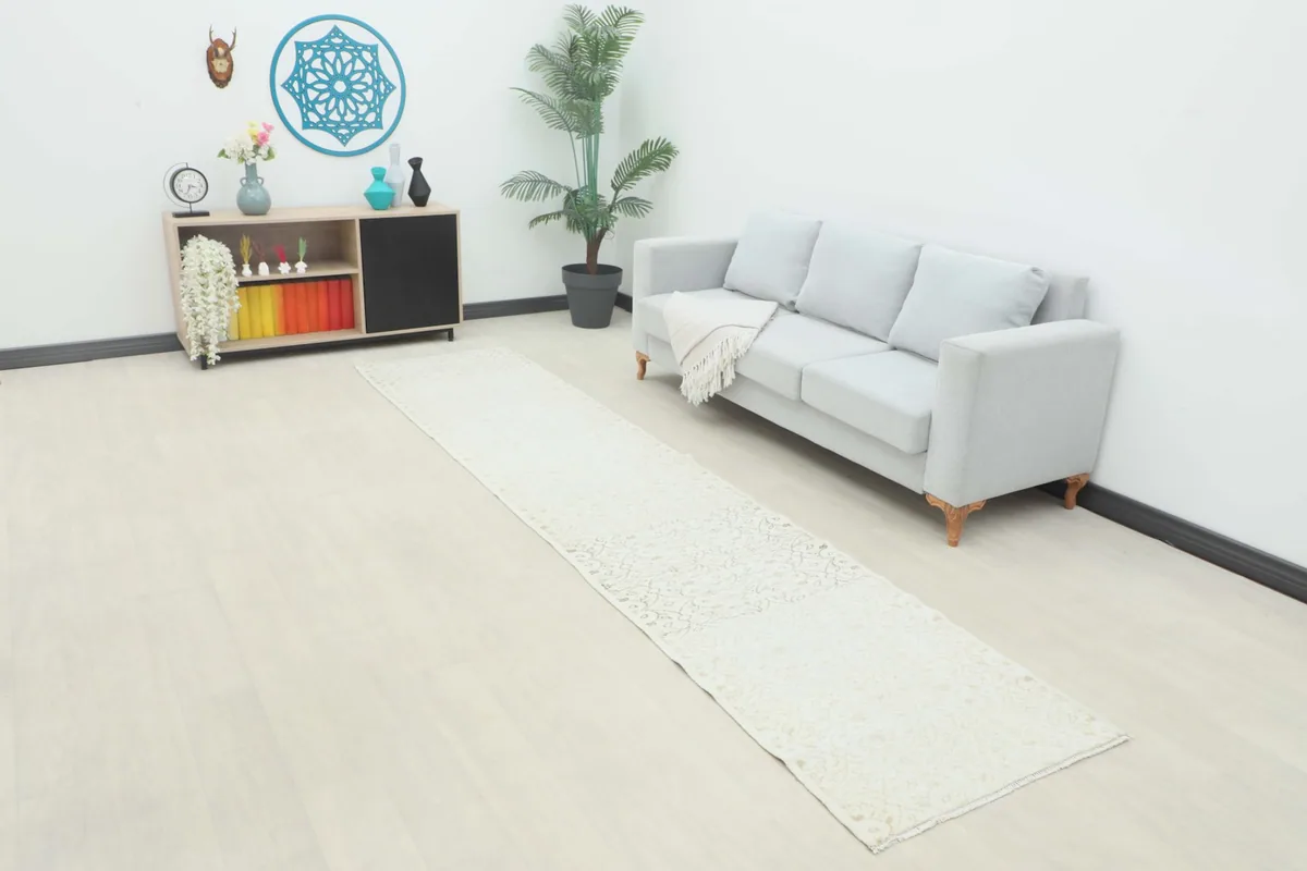 Vintage Anatolian runner displayed in a modern room setting with a sofa and decor.
