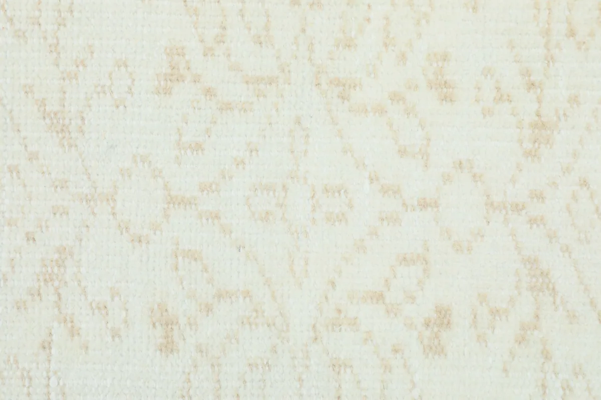 Macro shot of the low wool pile texture, highlighting the cream and tan threads.
