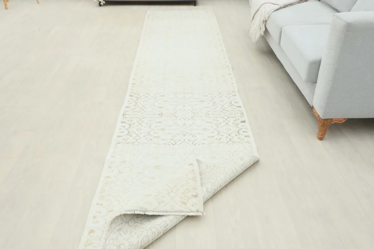 Runner partially folded, revealing the underside and confirming its pliable, hand-knotted construction.