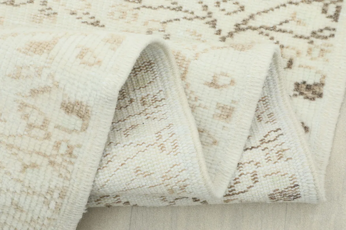 Close-up of the rug's fold, showcasing the density of the knots and the vintage wear.