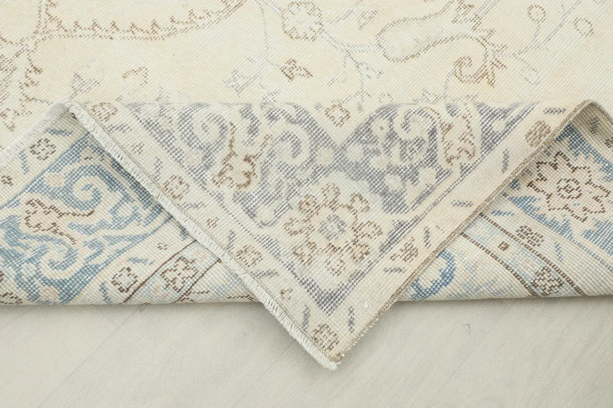 Corner of the rug folded back to show the reverse side of the hand-knotted cotton foundation.