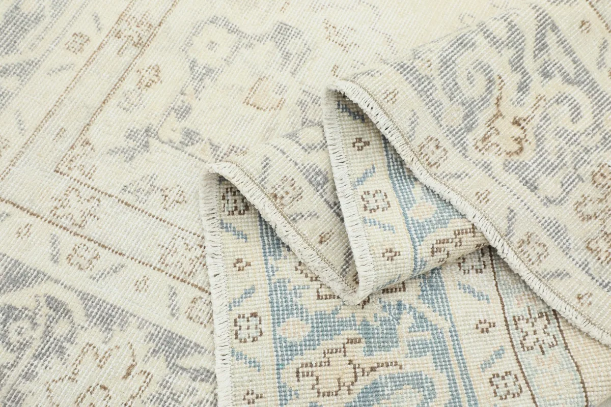The rug folded to reveal the thickness and detail of the hand-knotted construction from the side.