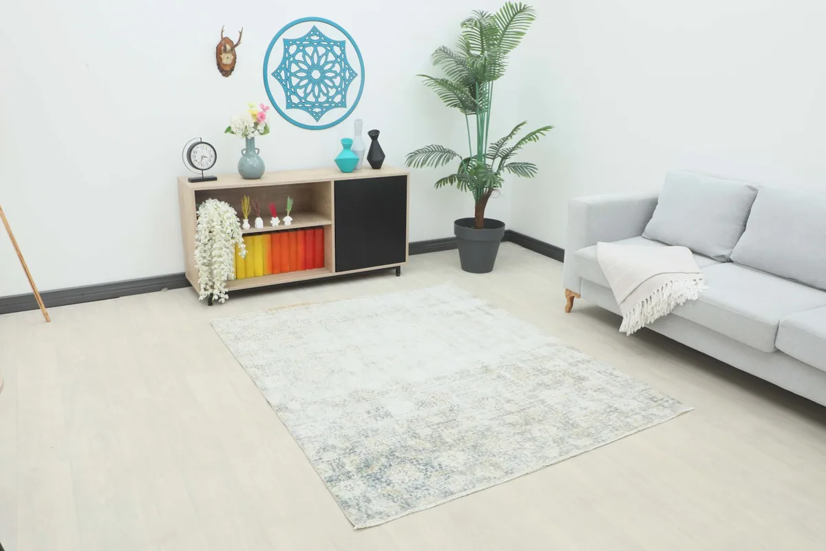 Angle view of the faded blue beige geometric rug in a modern living room setting.