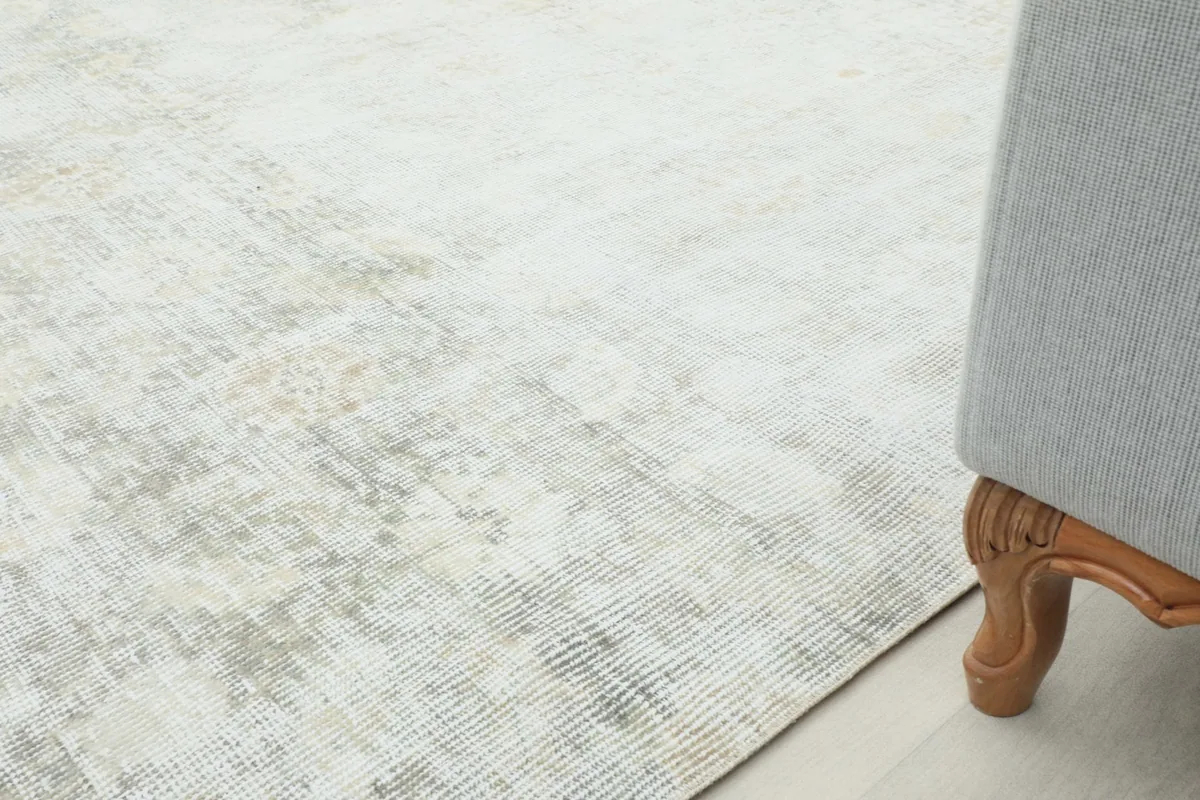 Close-up of the rug near a sofa leg, demonstrating its scale and integration into a room.