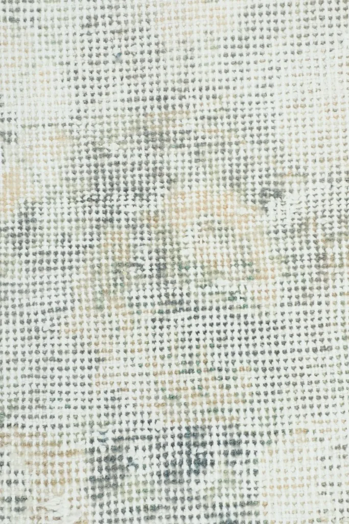 Close-up showing the low pile texture and distressed wool fibers of the rug.