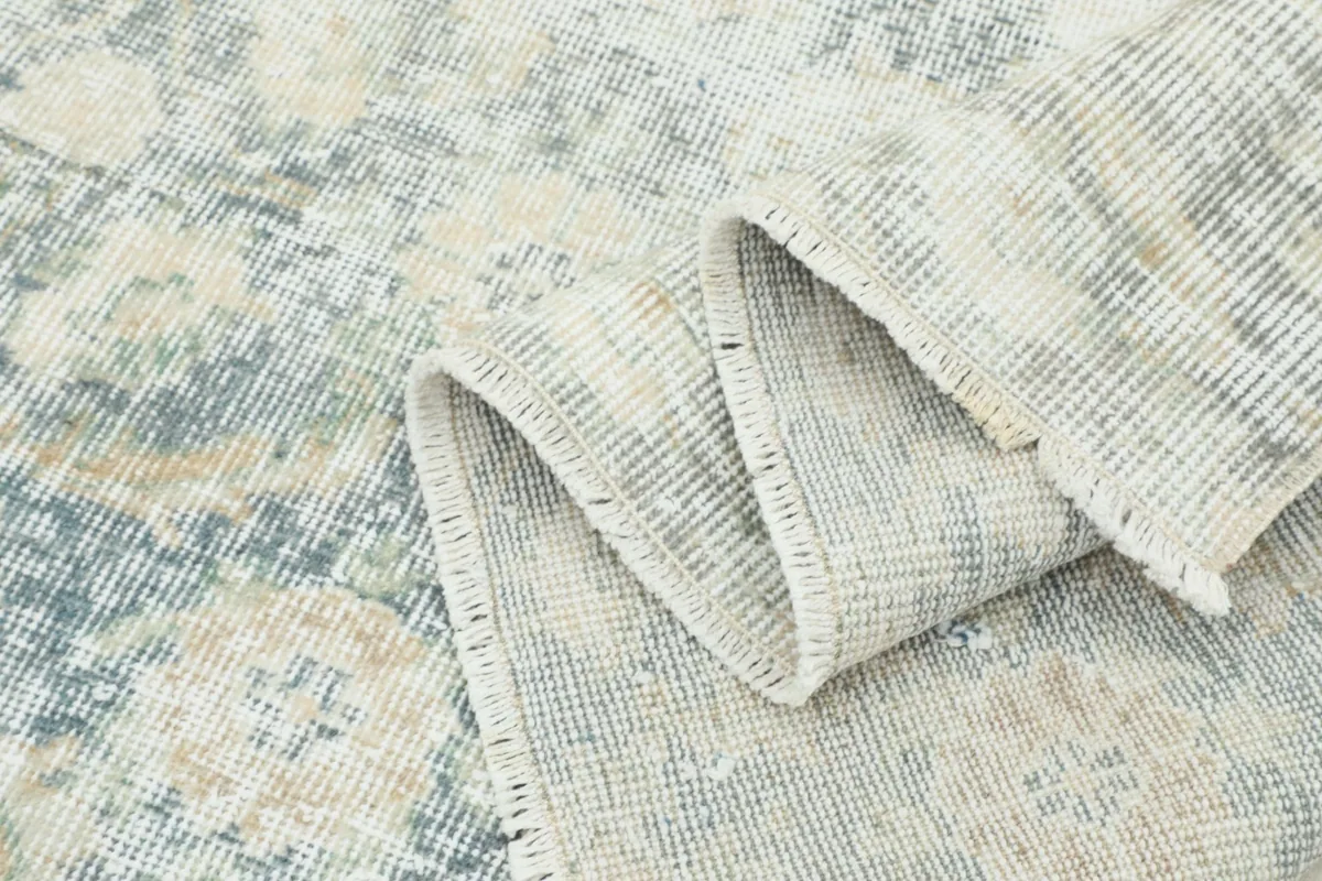 Rolled section of the rug, showcasing the flexible nature and construction of the vintage piece.