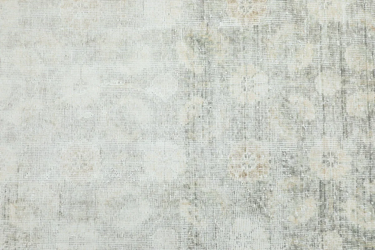 Overhead view showing the subtle geometric patterns and varying color saturation of the rug.