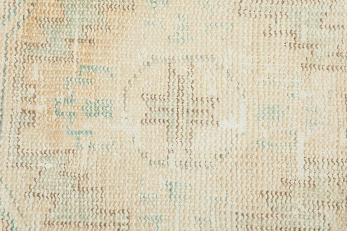 Macro shot of the low wool pile and the intricate hand-knotted texture of the rug